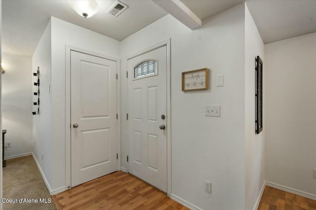 foyer entrance with visible vents, baseboards, and light wood-style floors