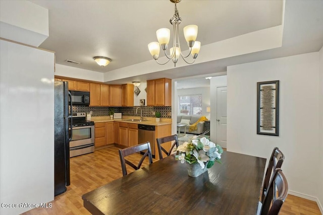 dining room with a chandelier, visible vents, and light wood-style flooring