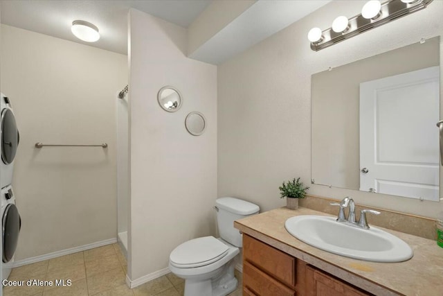 bathroom featuring vanity, toilet, stacked washer / drying machine, and walk in shower