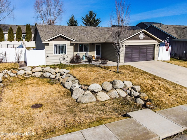 ranch-style home with an attached garage, fence, driveway, and a shingled roof