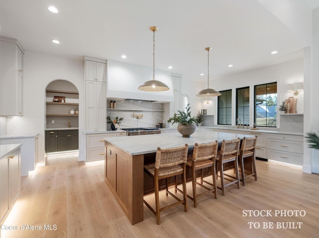 kitchen with open shelves, light wood-style floors, and a spacious island