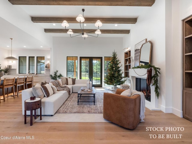 living room featuring a chandelier, beamed ceiling, and wood finished floors