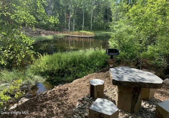 view of yard with a forest view and a water view