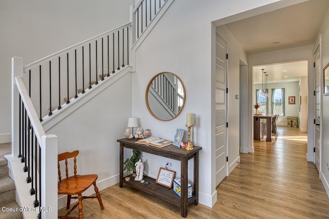 staircase with baseboards and wood finished floors