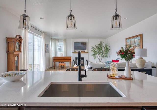 kitchen featuring a sink, open floor plan, and hanging light fixtures