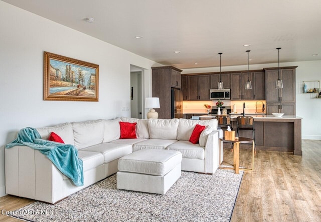 living area with light wood-style flooring and recessed lighting