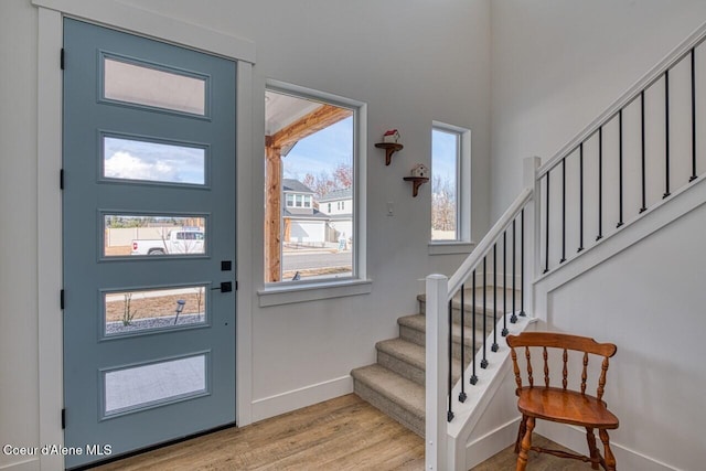 entrance foyer featuring stairs, baseboards, and light wood-type flooring