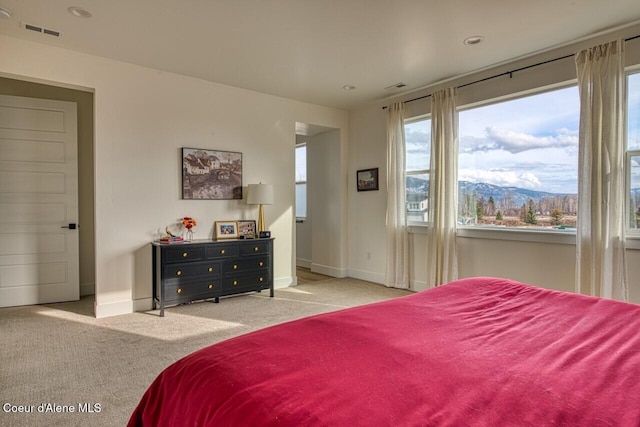 carpeted bedroom featuring visible vents, baseboards, and a mountain view