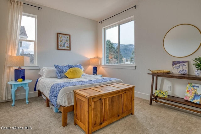 bedroom with light colored carpet and baseboards