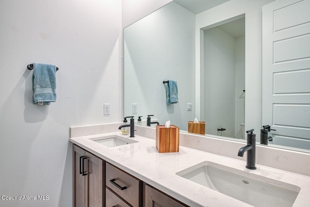 bathroom featuring a sink, toilet, and double vanity