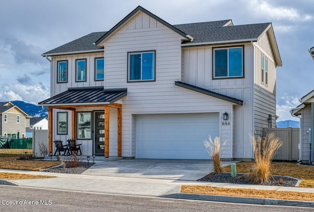 view of front of house featuring a standing seam roof, a garage, fence, and board and batten siding