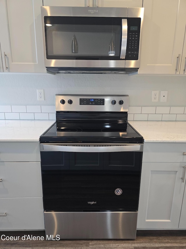 kitchen featuring white cabinetry, backsplash, and appliances with stainless steel finishes