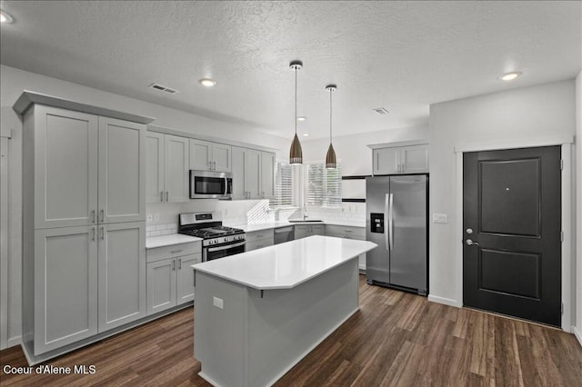 kitchen featuring dark wood-style floors, visible vents, gray cabinets, and stainless steel appliances