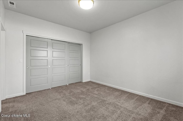 unfurnished bedroom featuring visible vents, baseboards, a closet, and carpet flooring