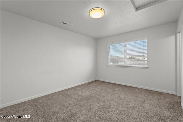 carpeted empty room featuring visible vents, baseboards, and a textured ceiling