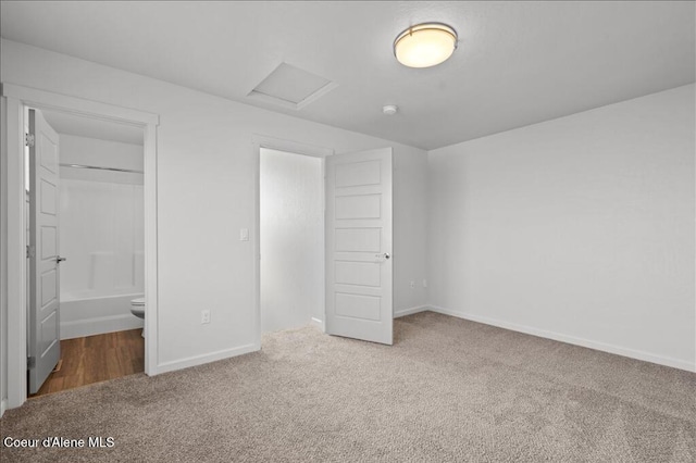 unfurnished bedroom with baseboards, carpet, and attic access