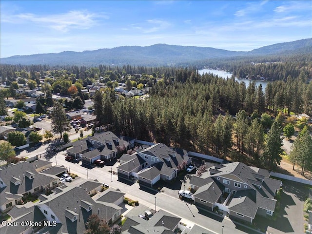 aerial view featuring a residential view, a forest view, and a water and mountain view