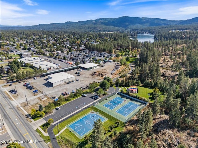 birds eye view of property featuring a view of trees and a water and mountain view