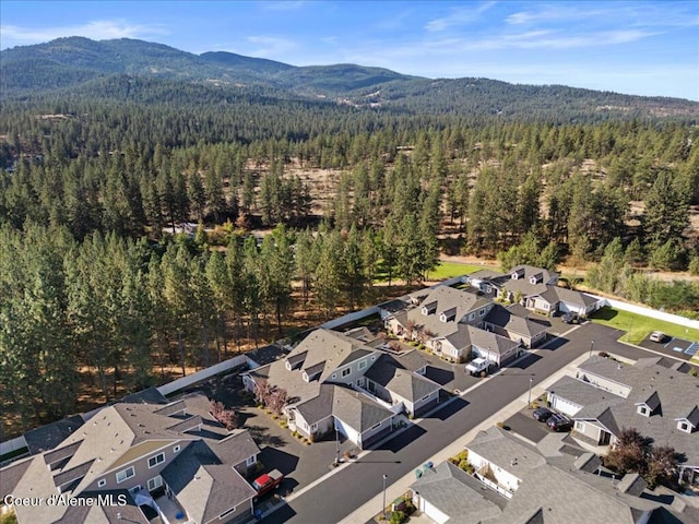 birds eye view of property featuring a mountain view, a residential view, and a wooded view