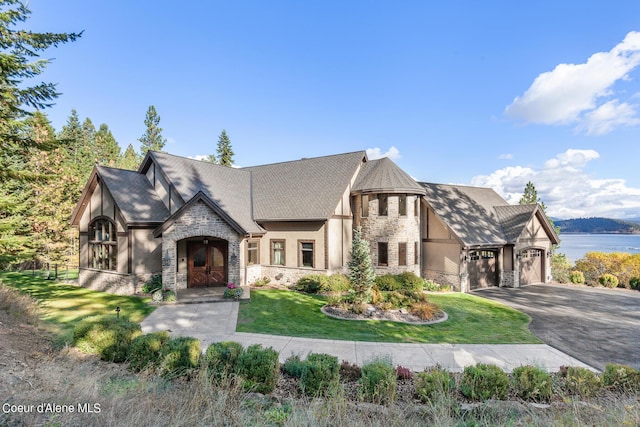 view of front of property with stone siding, stucco siding, driveway, and a front lawn