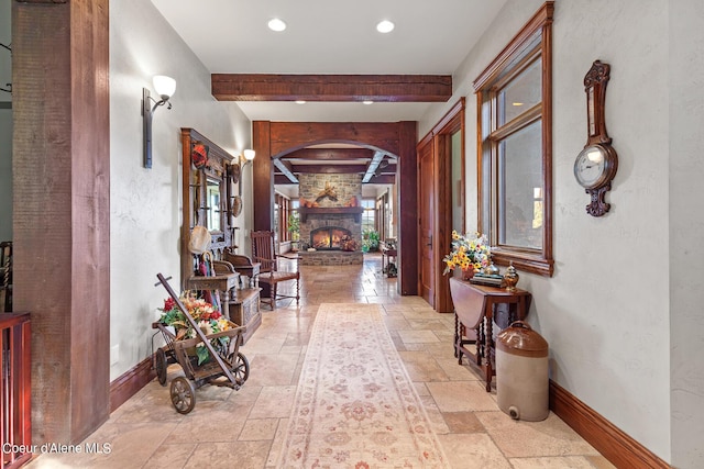 hall featuring recessed lighting, beam ceiling, baseboards, and stone tile floors