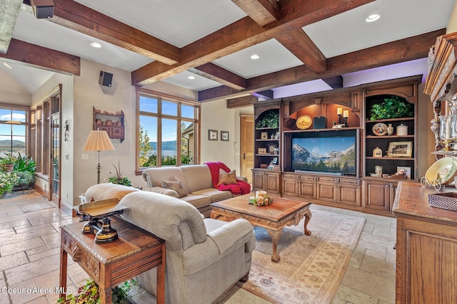 living area with a wealth of natural light, beamed ceiling, and stone tile flooring