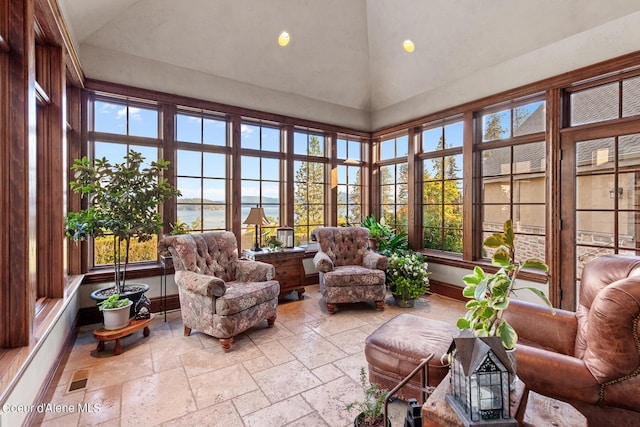 sunroom with visible vents, a healthy amount of sunlight, and vaulted ceiling