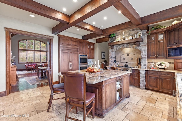 kitchen with open shelves, baseboards, built in appliances, and stone tile floors