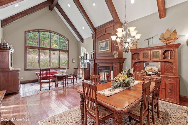 dining space featuring beamed ceiling, high vaulted ceiling, light wood-style floors, and an inviting chandelier