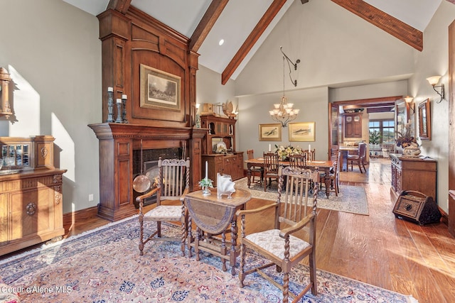 living room with a premium fireplace, beamed ceiling, high vaulted ceiling, and wood finished floors