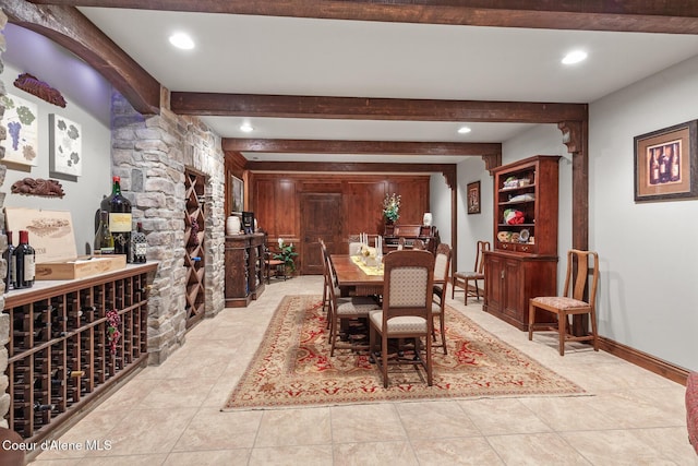 wine cellar with beamed ceiling, recessed lighting, and baseboards