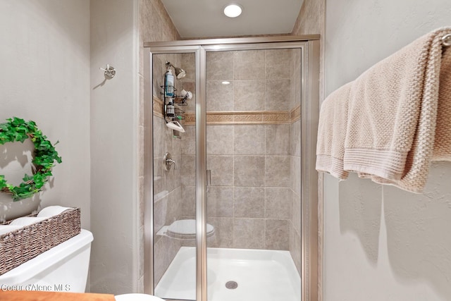 bathroom featuring a stall shower and toilet