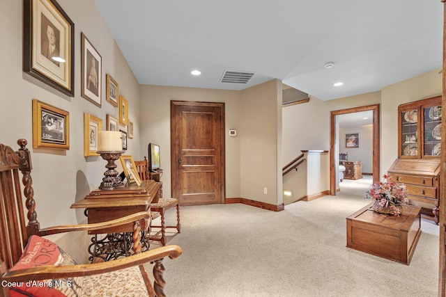 sitting room featuring visible vents, baseboards, recessed lighting, an upstairs landing, and light colored carpet