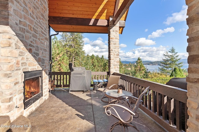 view of patio with area for grilling and an outdoor stone fireplace