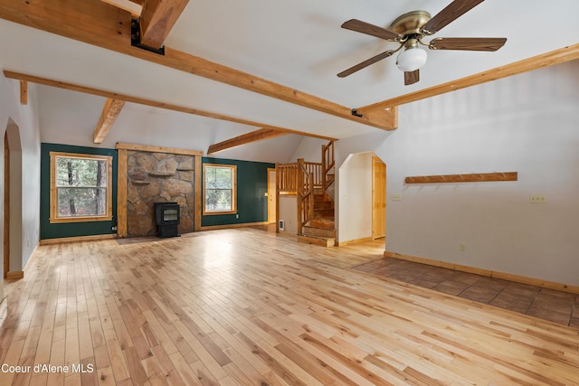 unfurnished living room featuring a wealth of natural light, stairs, a ceiling fan, and wood finished floors