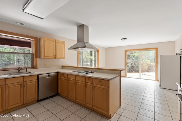 kitchen with light countertops, a peninsula, island range hood, white appliances, and a sink