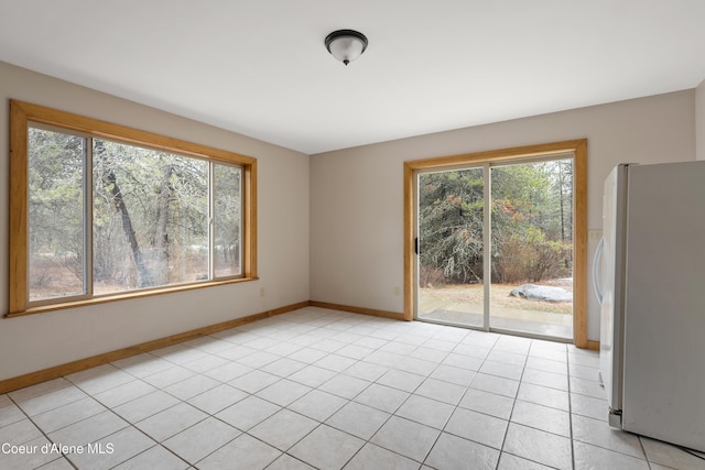 spare room with light tile patterned floors and baseboards