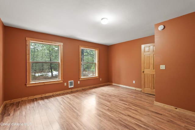 unfurnished room with baseboards and light wood finished floors