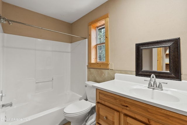 bathroom featuring toilet, vanity, and bathing tub / shower combination