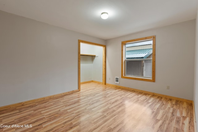 spare room featuring light wood-type flooring and baseboards