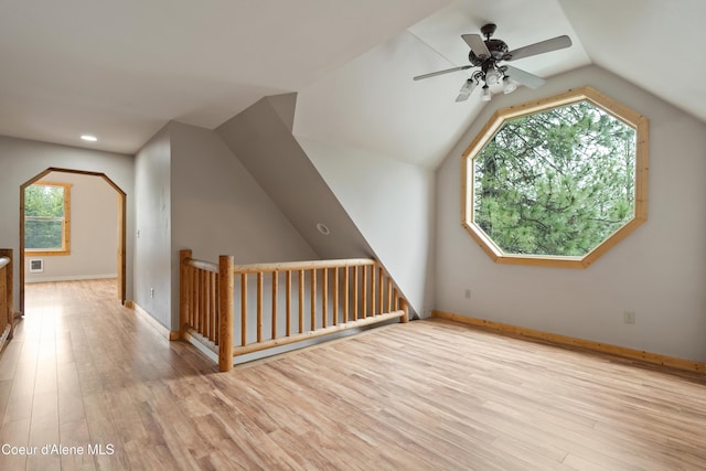 additional living space featuring vaulted ceiling, wood finished floors, baseboards, and ceiling fan