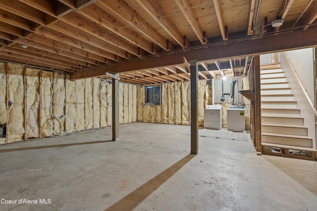 unfinished below grade area featuring washing machine and dryer and stairs