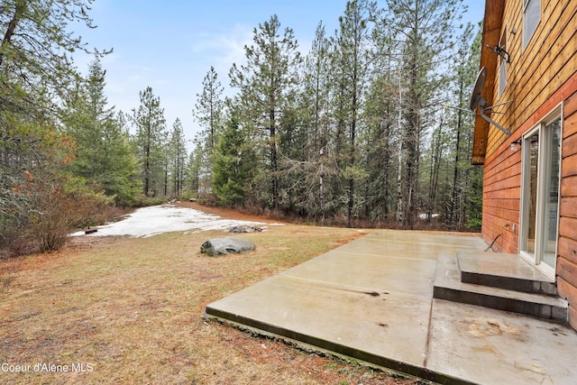 view of yard with a patio area and a wooded view