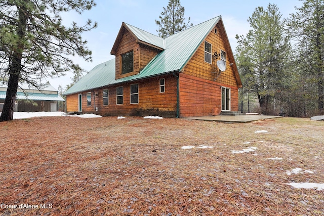 rear view of property featuring a patio and metal roof