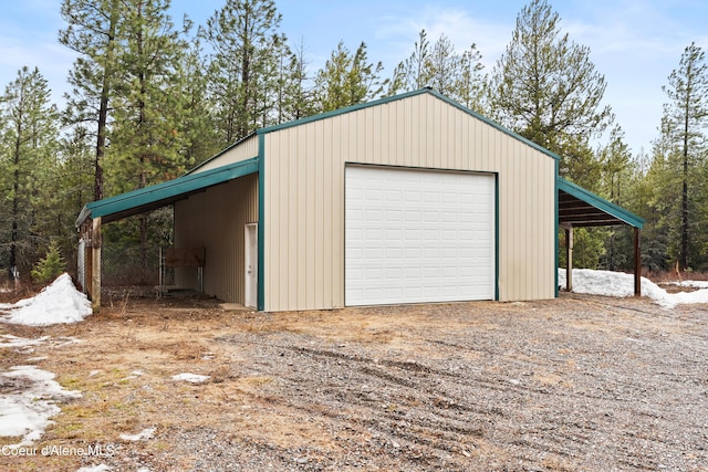 garage with driveway and a detached garage