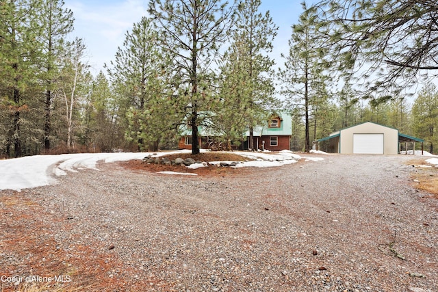 exterior space featuring an outdoor structure, gravel driveway, and a garage