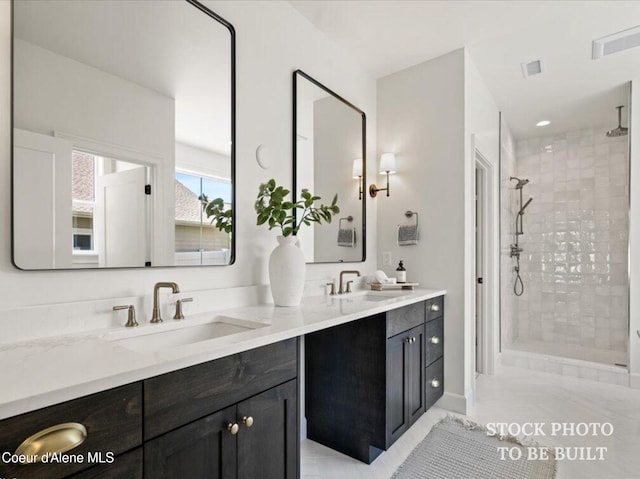 bathroom featuring double vanity, walk in shower, and a sink