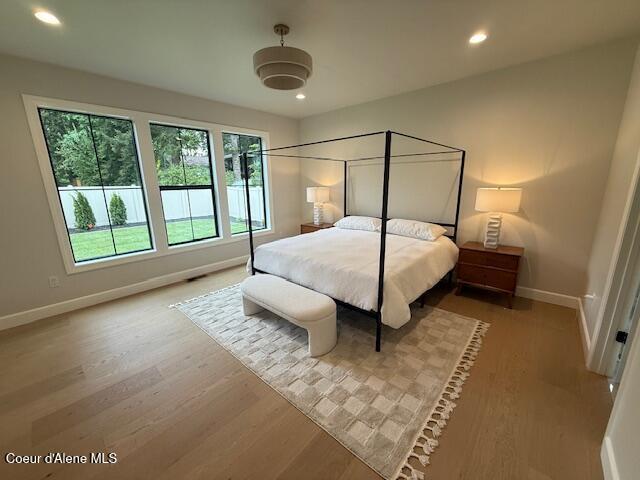 bedroom featuring baseboards, wood finished floors, and recessed lighting