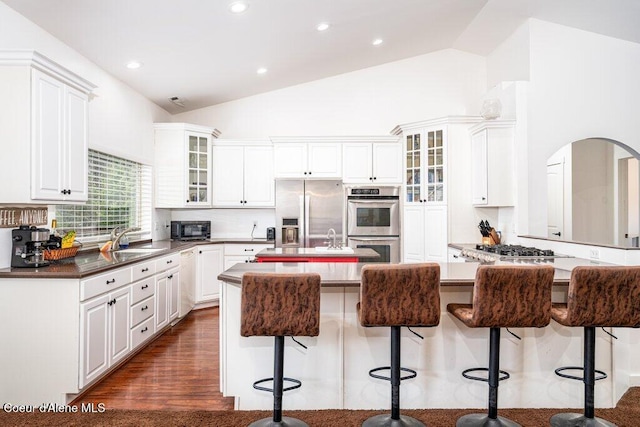 32722 N 10th Ave, Spirit Lake, ID 83869 - kitchen featuring stainless steel appliances, a kitchen island with sink, a sink, a breakfast bar, and white cabinetry