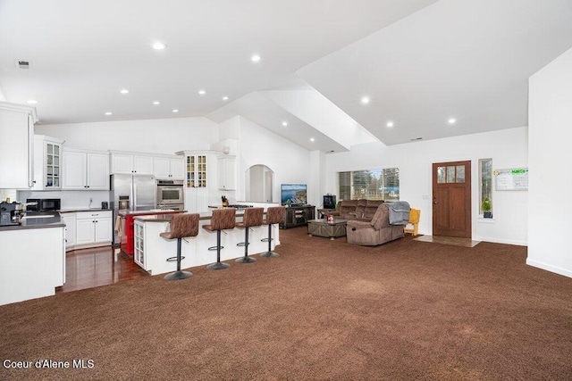 32722 N 10th Ave, Spirit Lake, ID 83869 - kitchen with stainless steel refrigerator with ice dispenser, a kitchen island, white cabinetry, open floor plan, and dark carpet